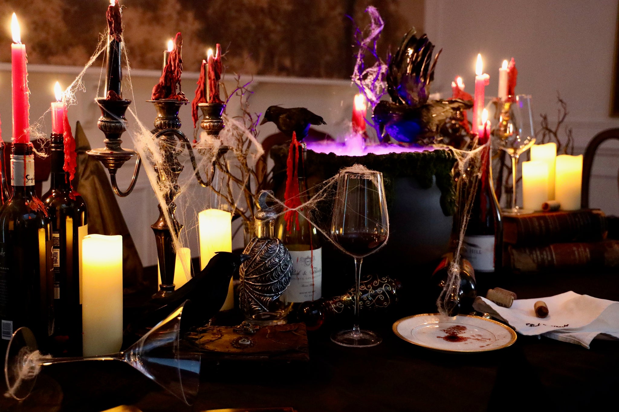Halloween-themed table setup with candles, bottles, and decorative elements.